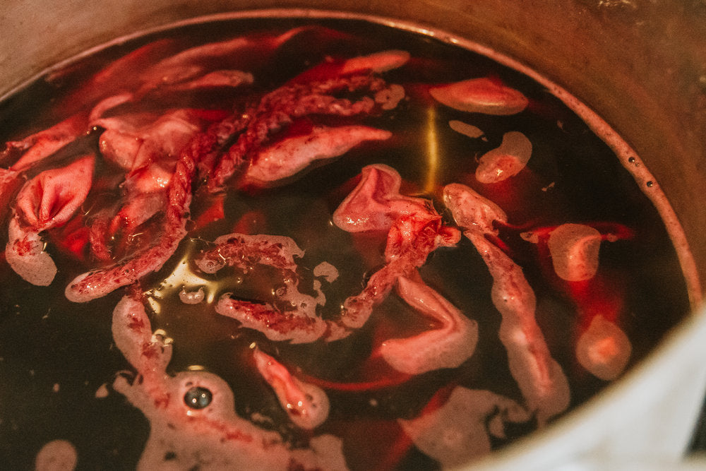 Cooked animal parts in a pot with a dark liquid