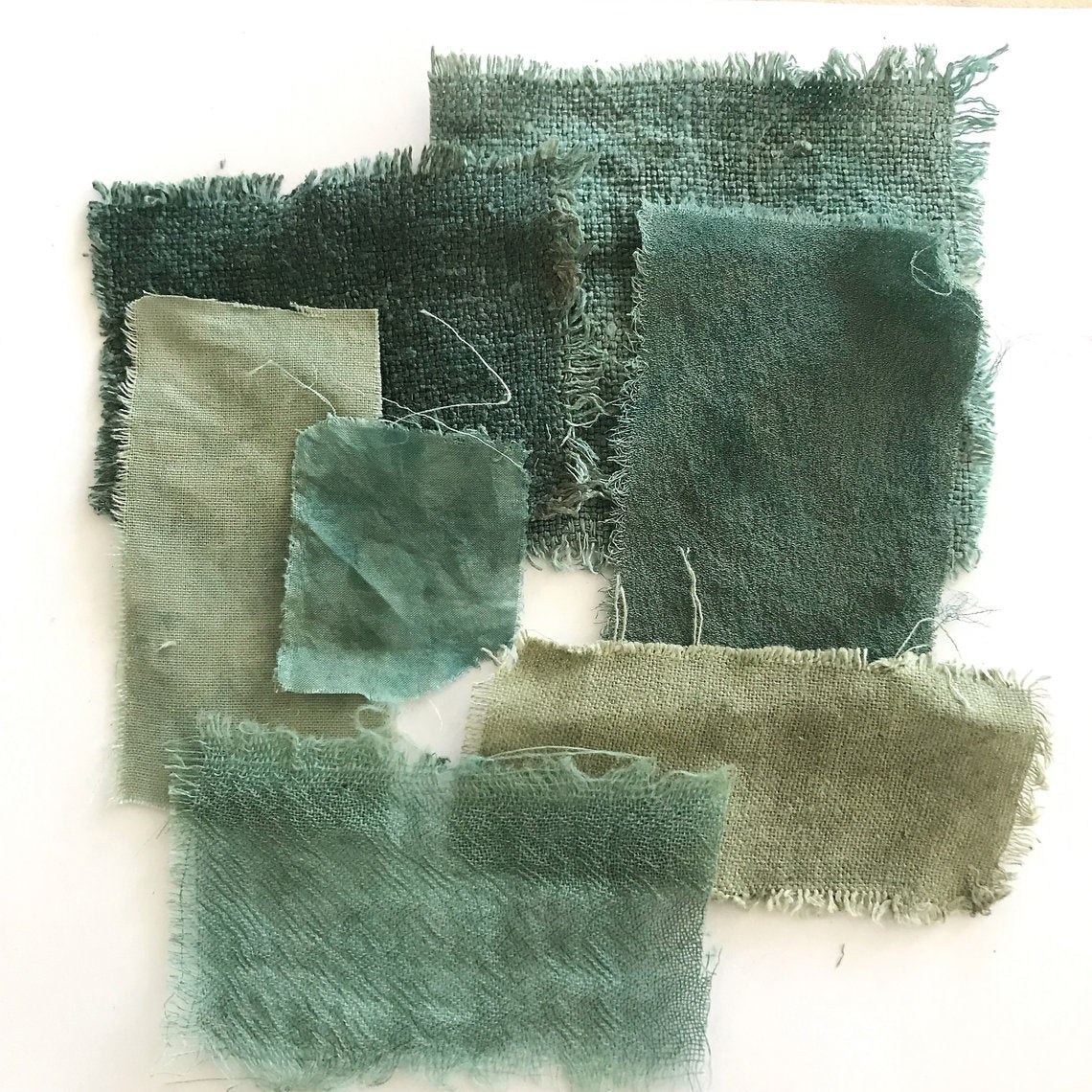 Collection of green fabric swatches on a white background