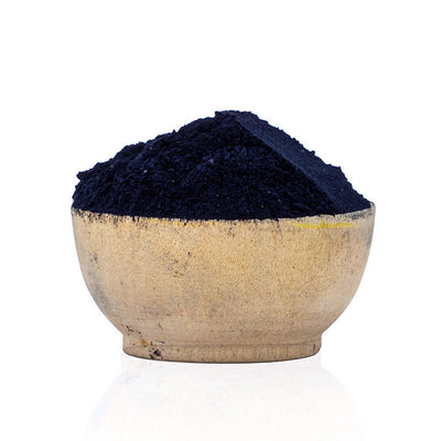Navy blue powder in a beige bowl on a white background