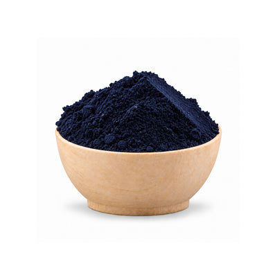 Navy blue powder in a beige bowl on a white background