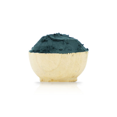 Wooden bowl filled with green powder on a white background