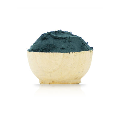 Wooden bowl filled with green powder on a white background