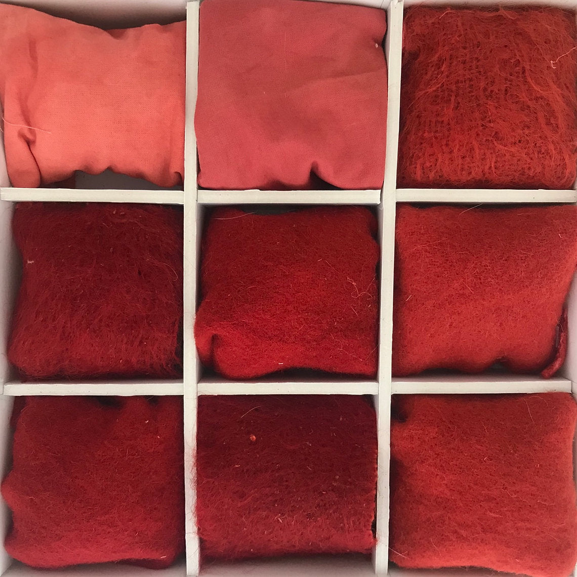 Red fabric swatches arranged in a grid pattern.