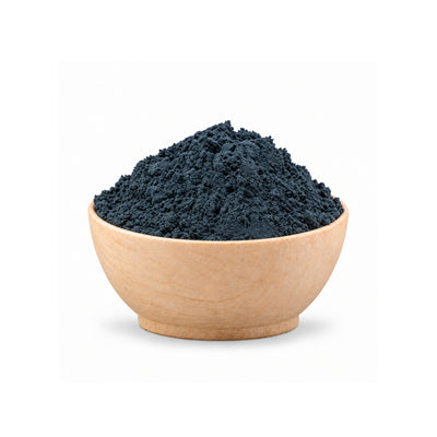 Wooden bowl filled with dark blue powder on a white background