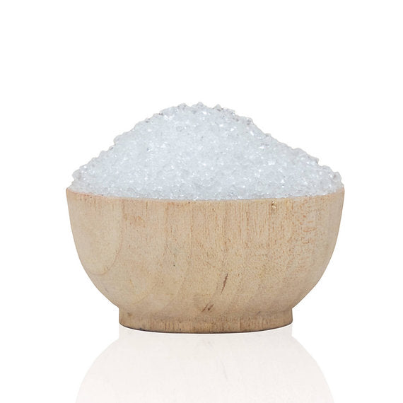 Wooden bowl filled with white granulated product on a white background
