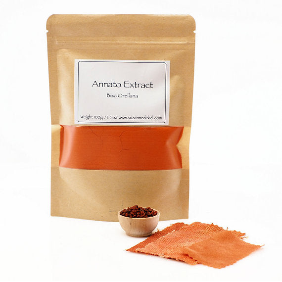 Kraft paper packaging of Annato Extract with a small bowl and sample on a white background