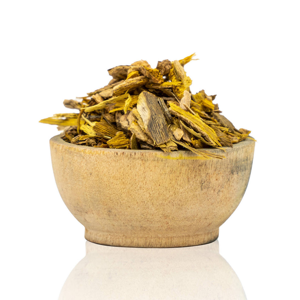 Wooden bowl filled with dried herbs on a white background