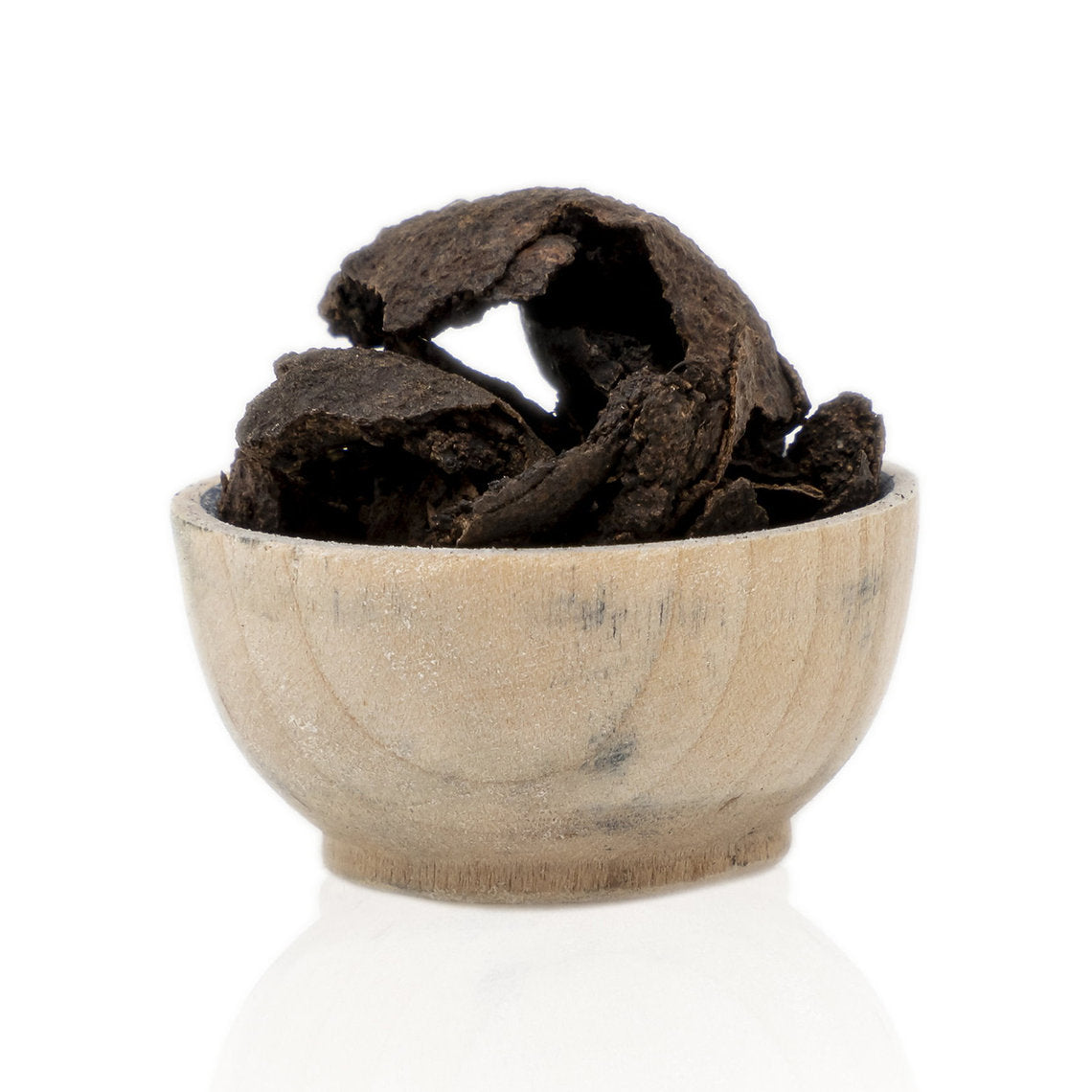 Wooden bowl with Black Walnut Hulls (Juglans Negra) dark brown substance on a white background