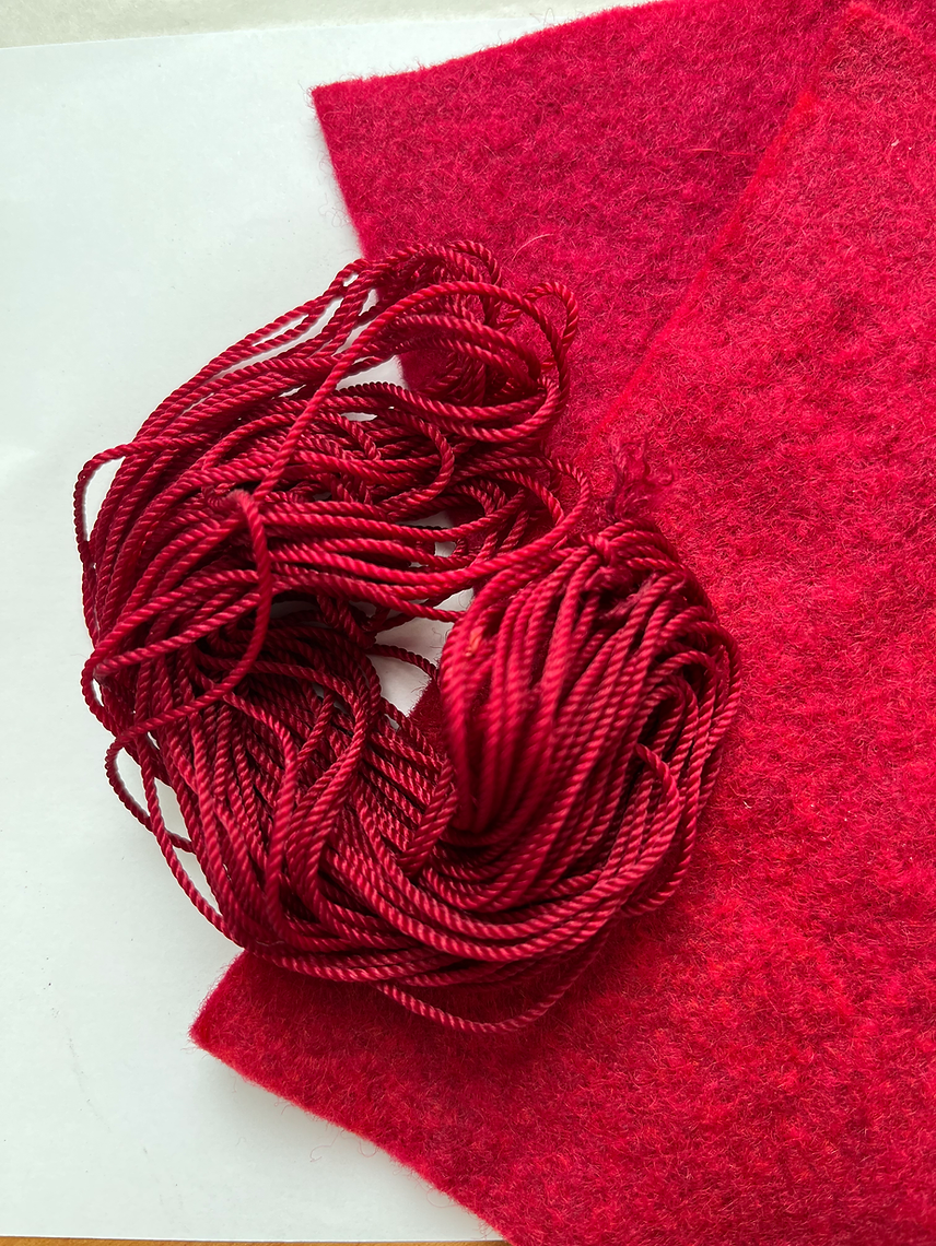Red yarn ball on a red fabric background
