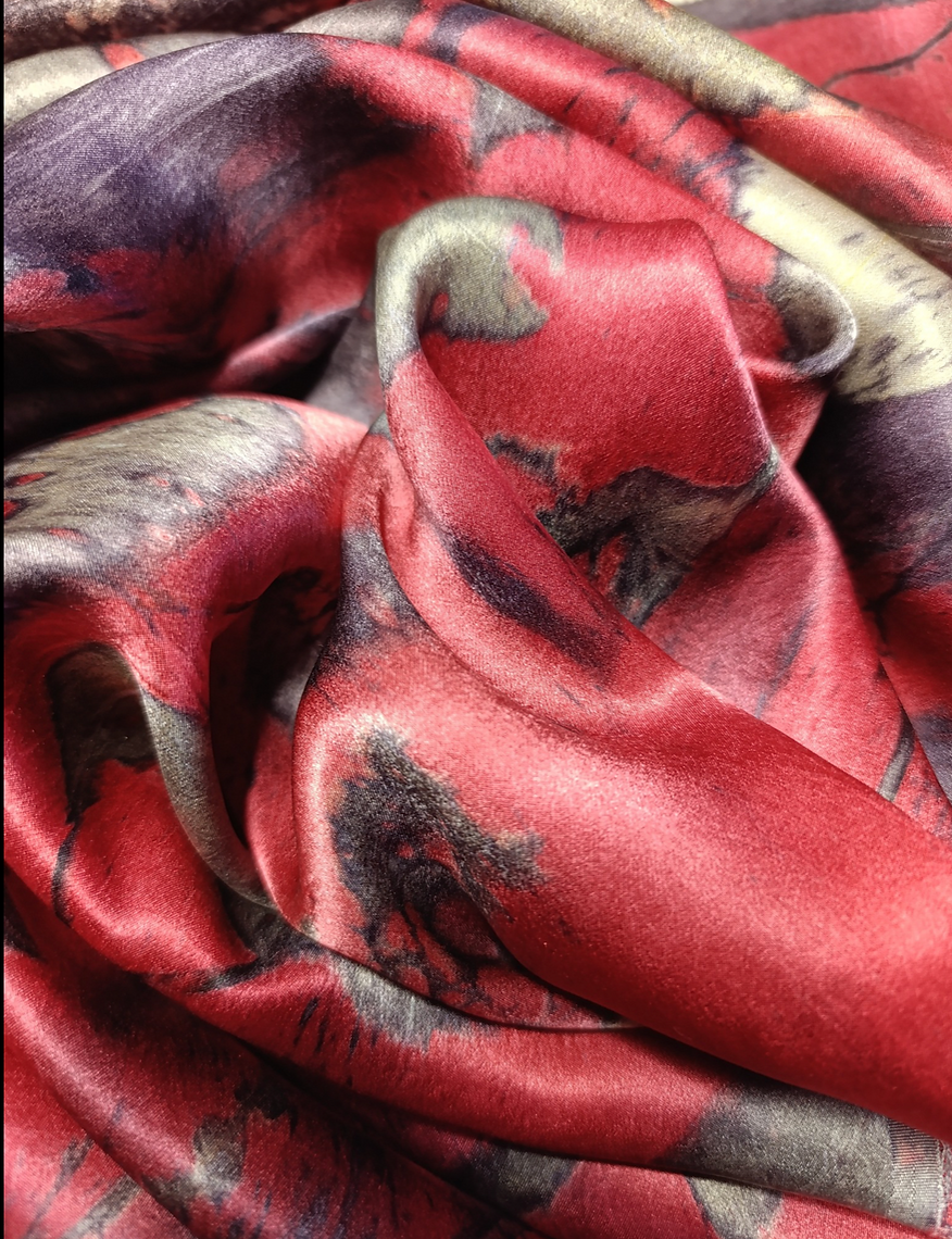 Close-up of patterned fabric with red, black, and beige colors.