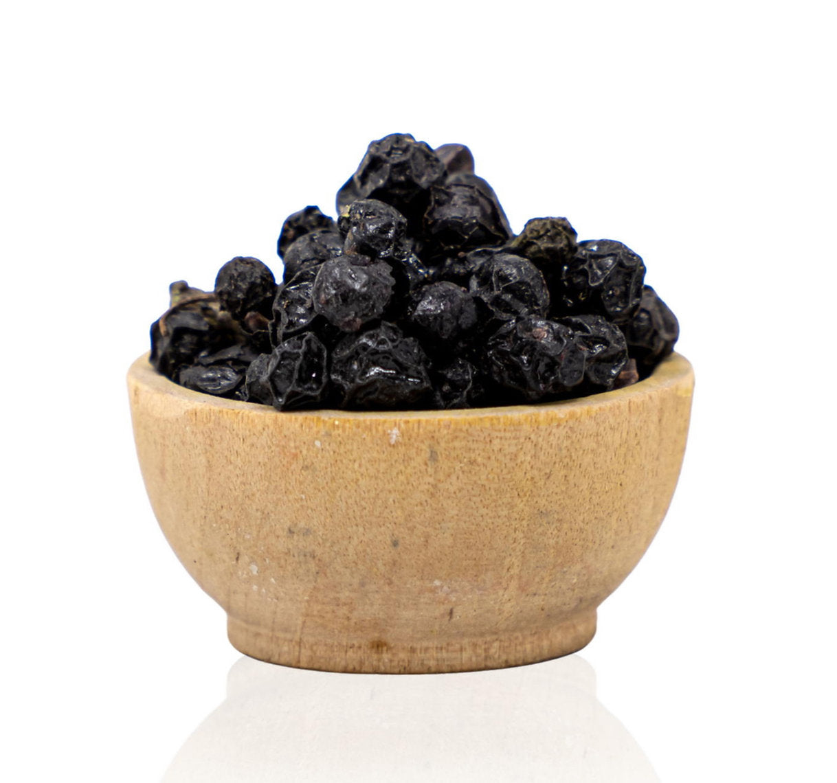 Wooden bowl filled with black dried fruits on a white background