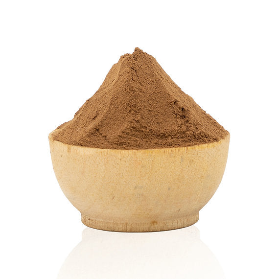 Brown powder in a wooden bowl on a white background