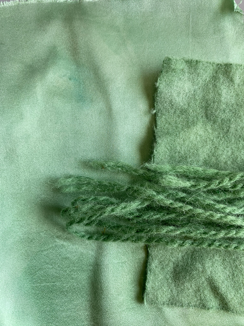 Close-up of green fabric with a textured pattern on a matching fabric background