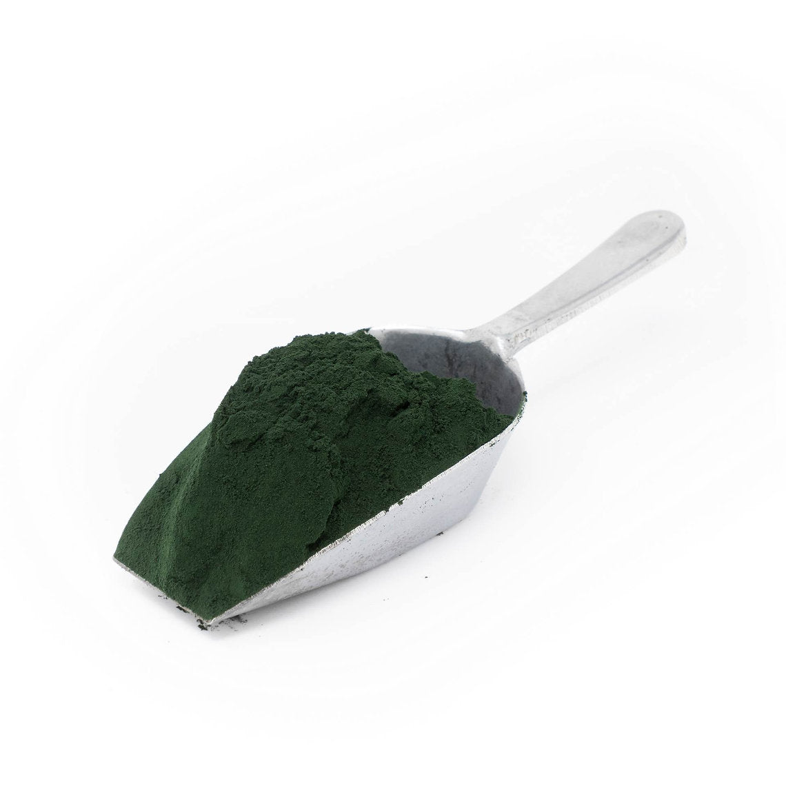 Metal scoop filled with green powder on a white background