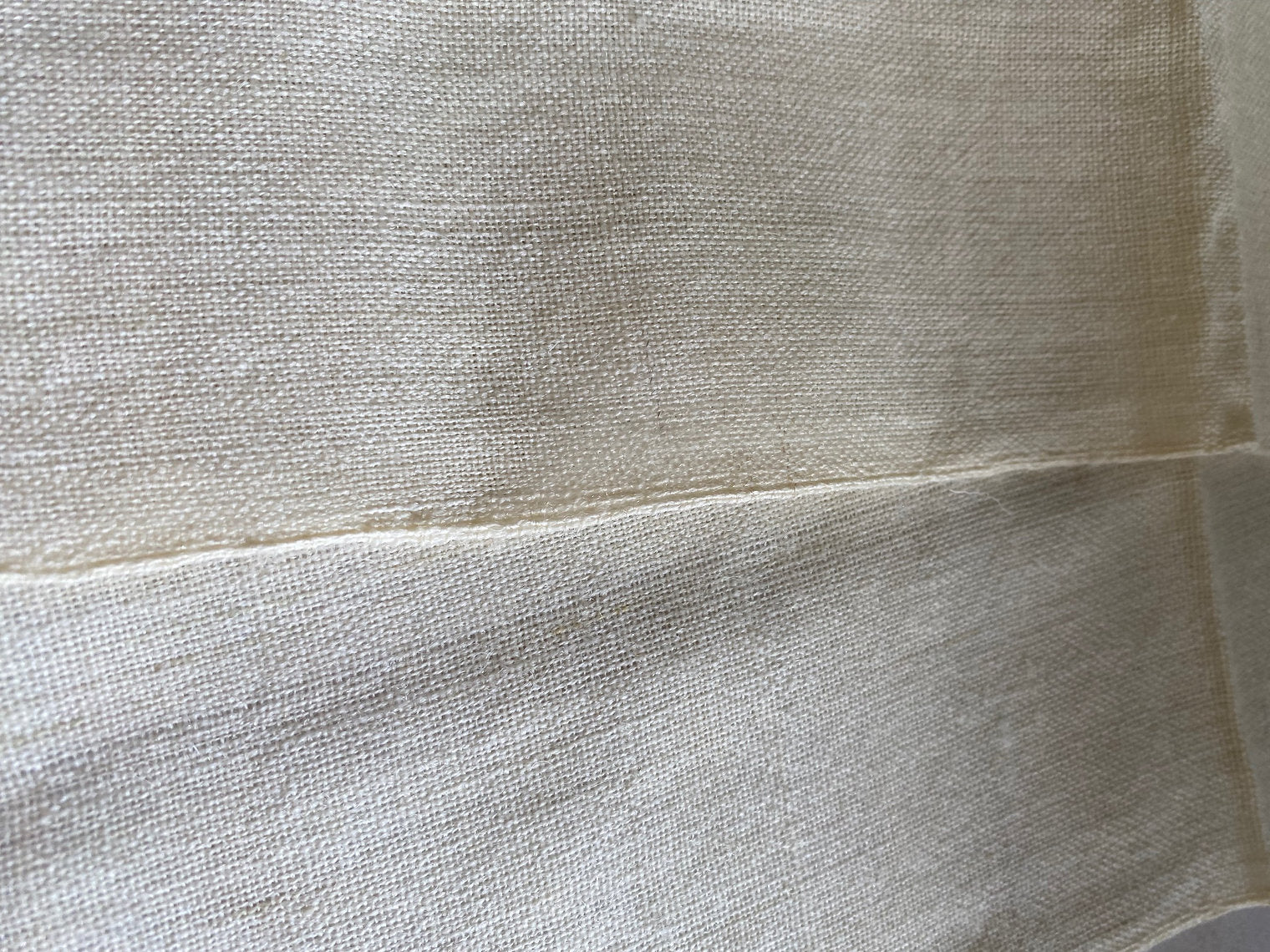 Close-up of beige fabric with a visible seam
