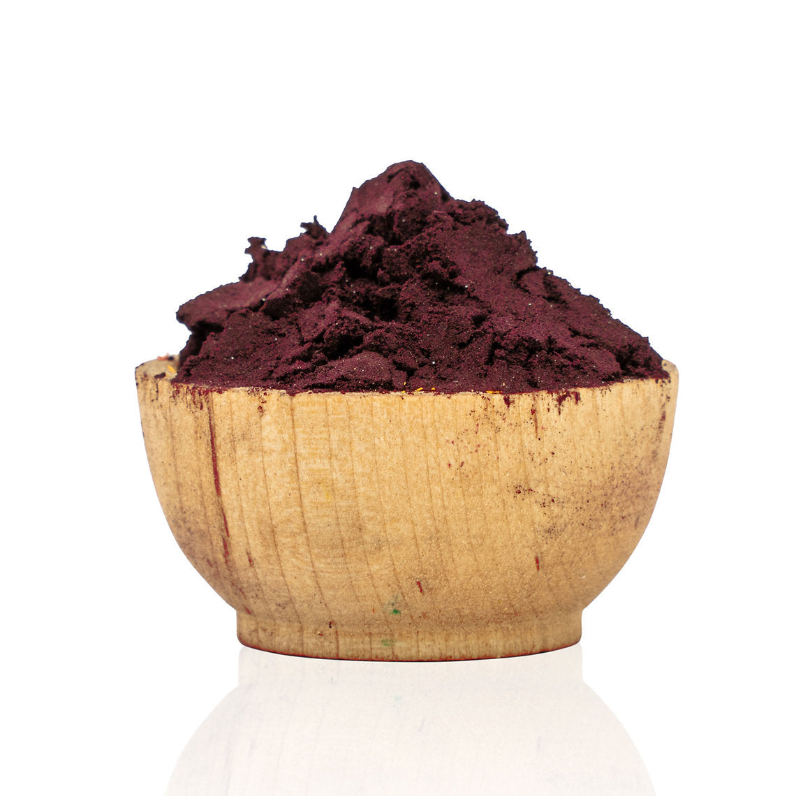 Wooden bowl filled with dark red powder on a white background