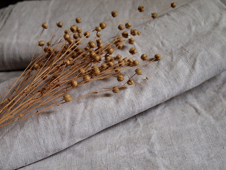 Dried flowers on a textured gray fabric surface