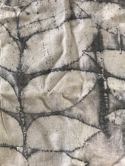 Textured fabric with abstract leaf pattern in black on a beige background