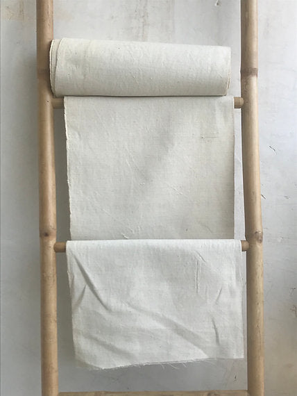 Wooden ladder with white fabric on a plain background