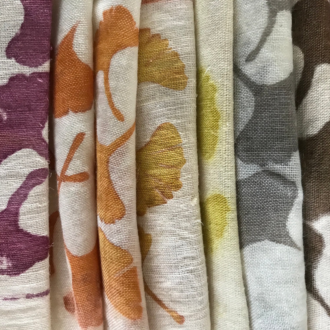 Collection of fabric swatches with floral and abstract patterns.