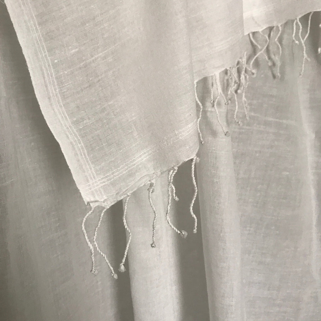 Close-up of a textured cotton muslin scarf with frayed edges
