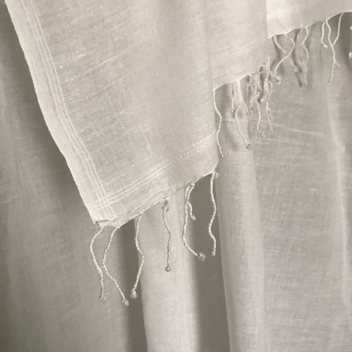 Close-up of a textured cotton muslin scarf with frayed edges