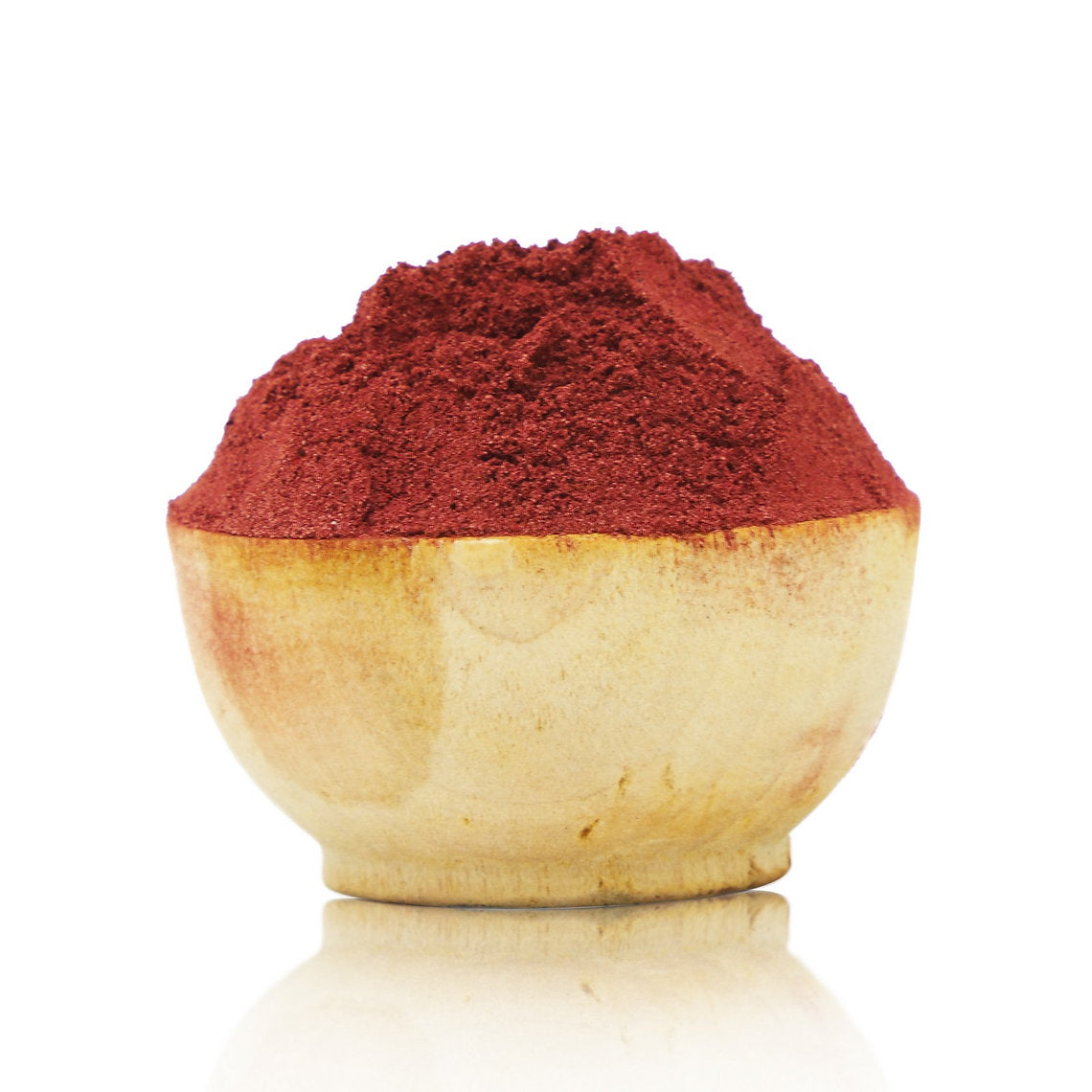 Red powder in a wooden bowl on a white background