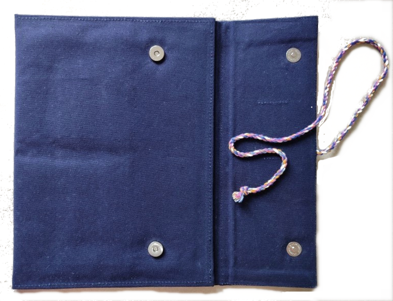 Blue fabric pouch with buttons and a strap on a white background