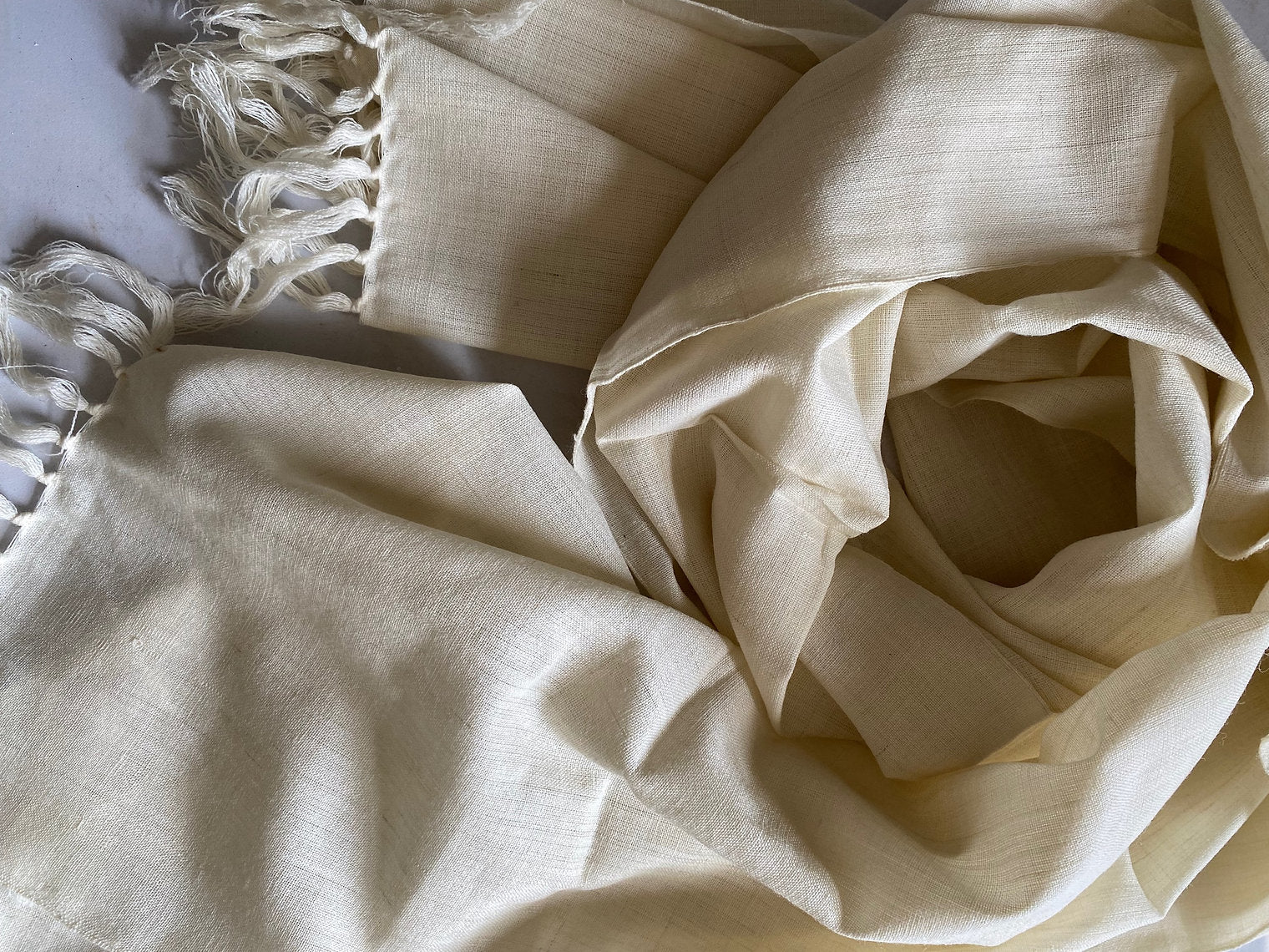 Beige fabric with frayed edge on a light background
