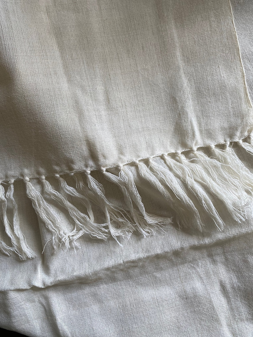 Close-up of a textured white fabric with frayed edges