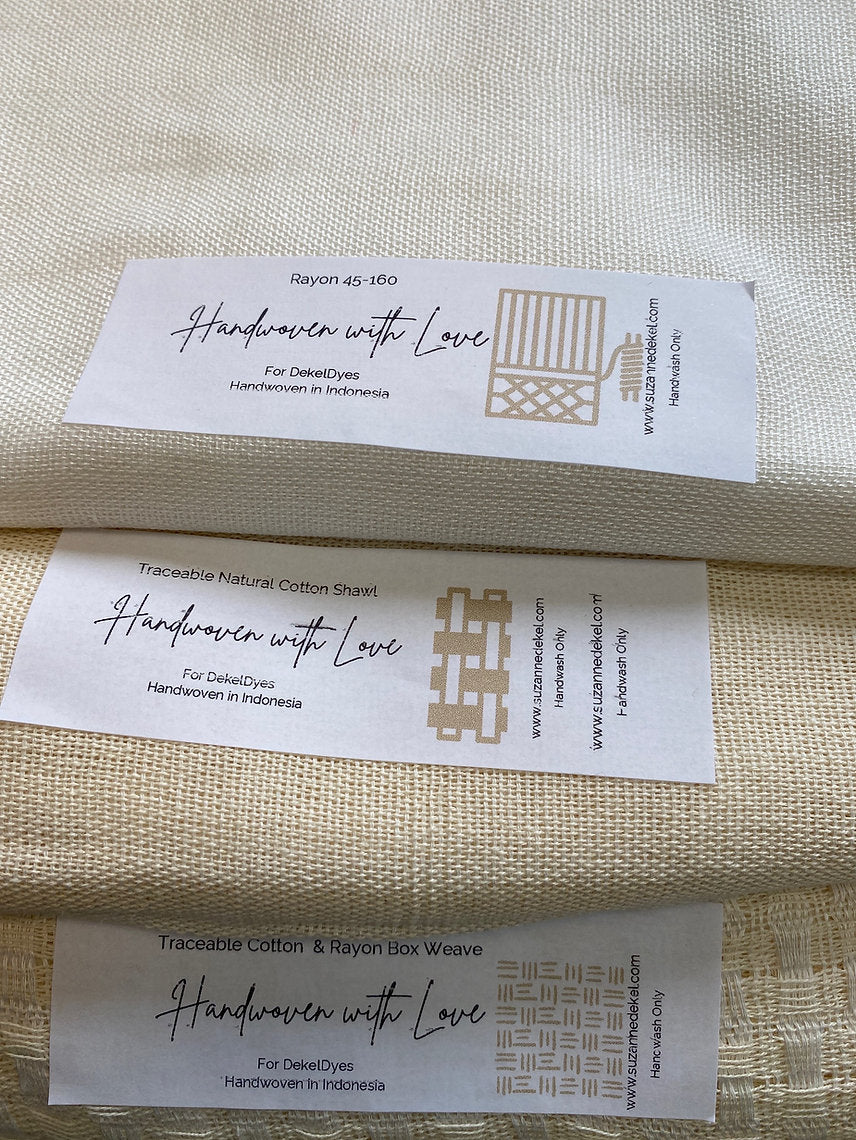 Close-up of fabric with 'Handwoven with Love' labels on a beige background