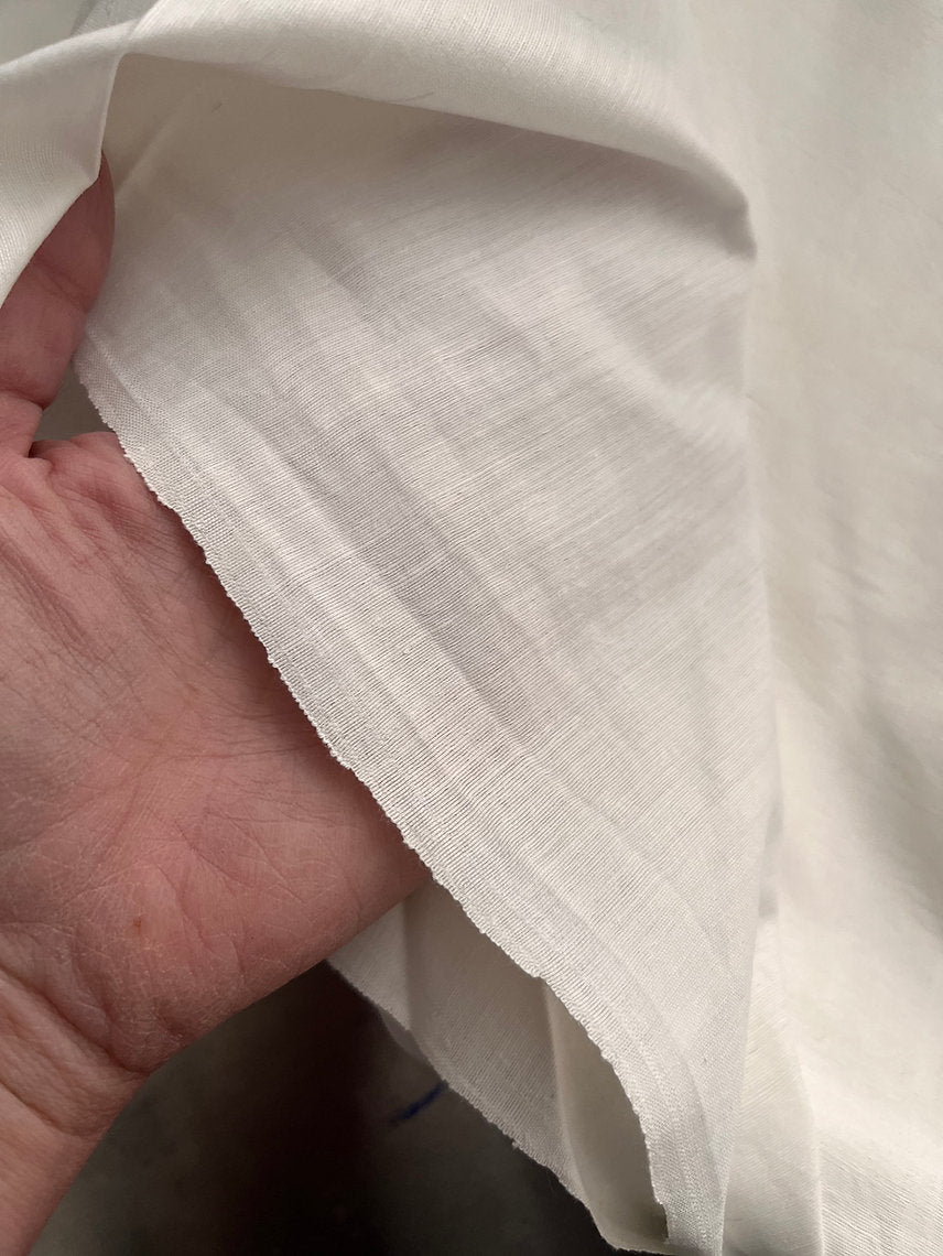 Close-up of white fabric held by a hand