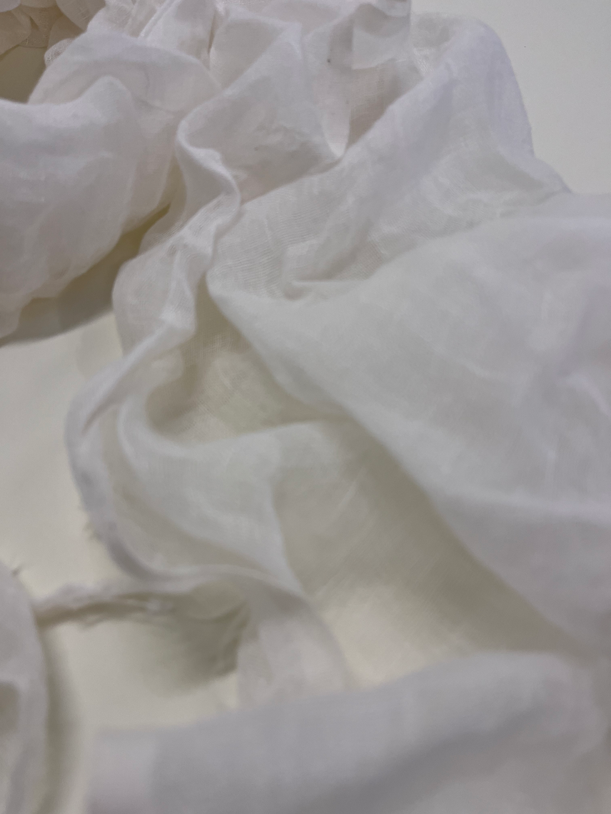 Close-up of white fabric with folds on a light background
