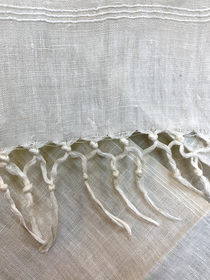 Textured linen scarfwith a fringed edge on a light background