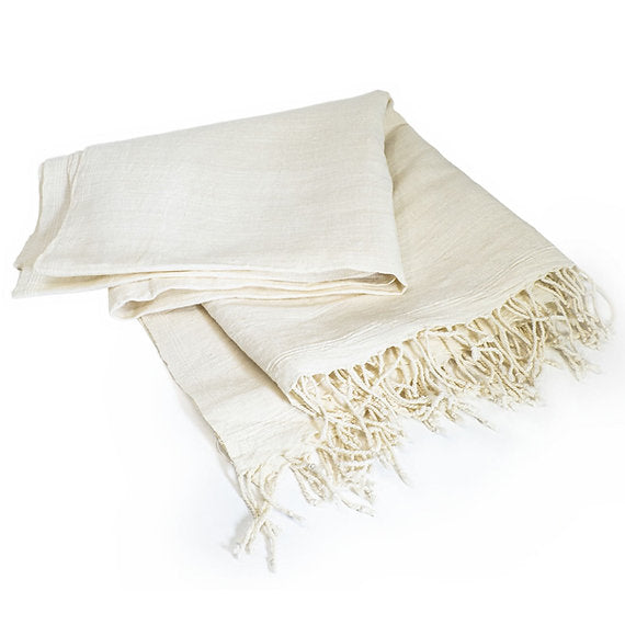 Beige towel with fringes on a white background