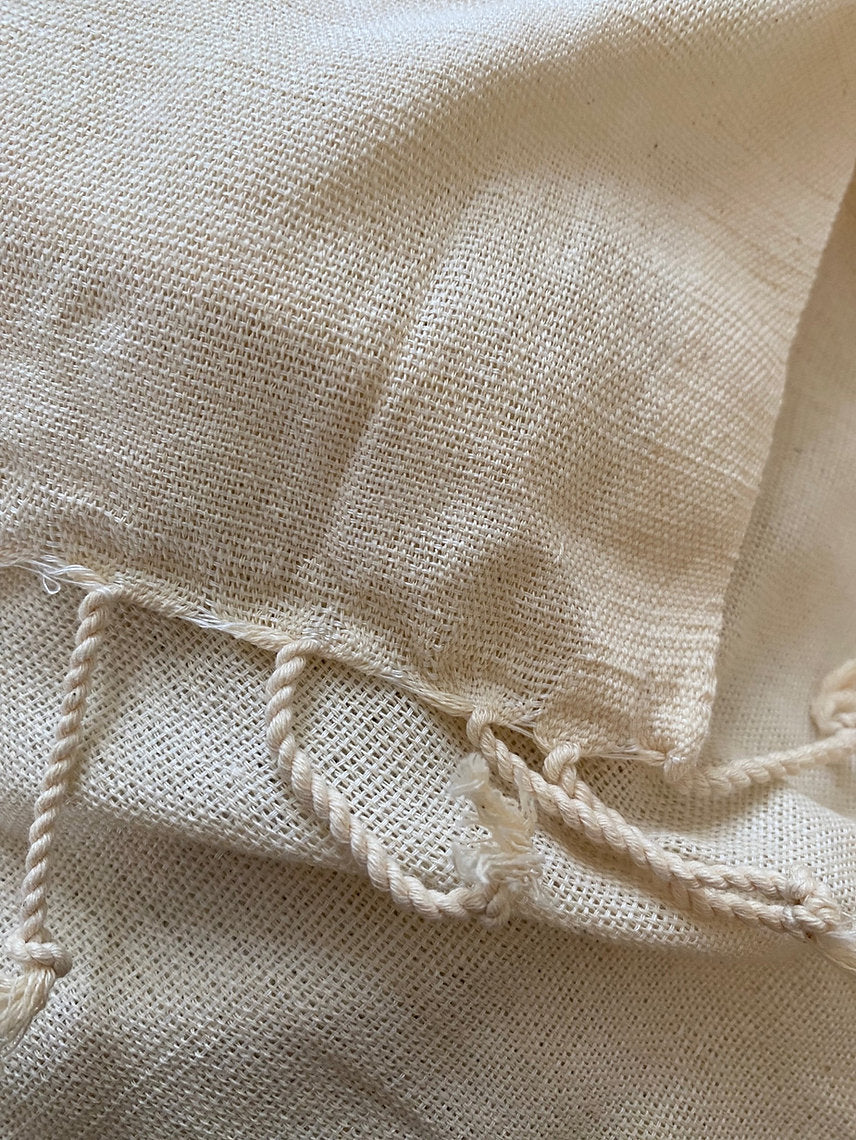 Close-up of textured beige fabric with frayed edges