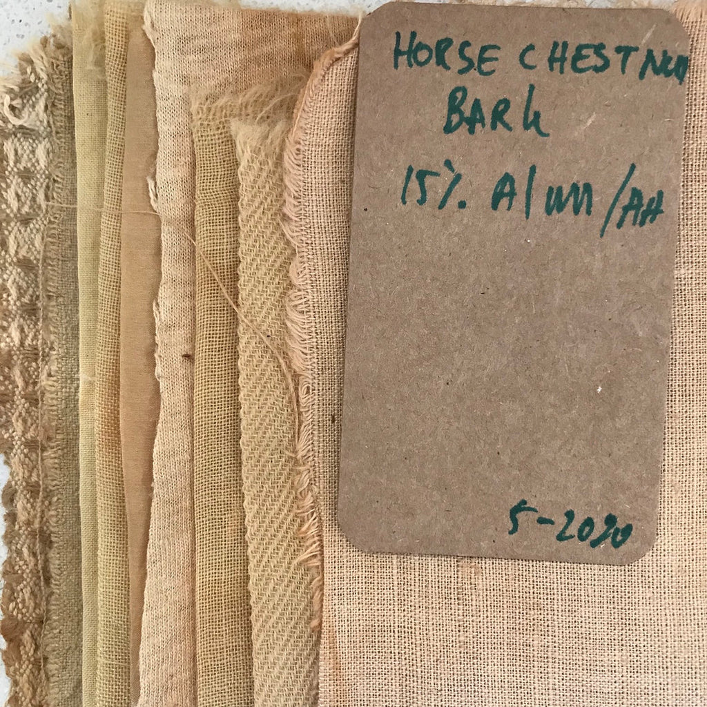 Collection of fabrics dyed horse chestnut bark samples with a label on a textured background