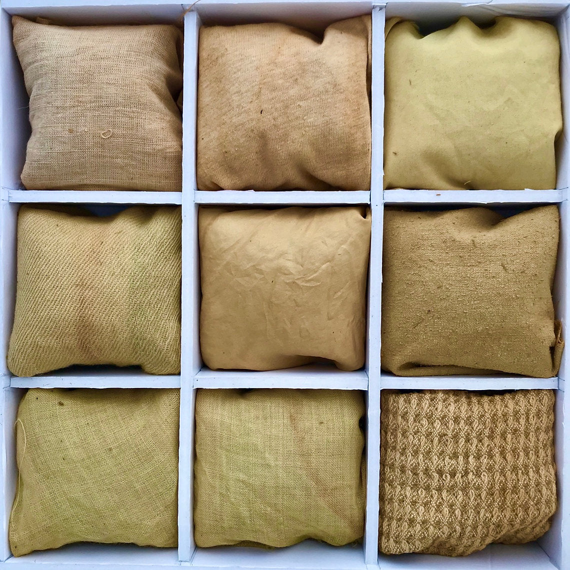 Nine brown fabric dyed Horse Chestnut Bark (Aesculus hippocastanum) bags arranged in a 3x3 grid within a white box.
