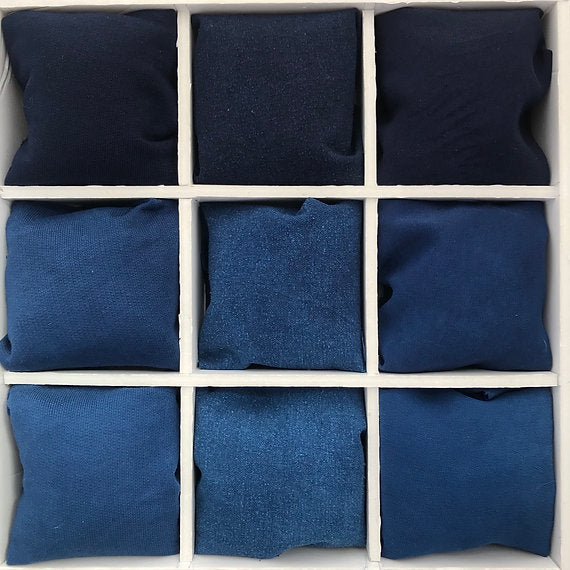 Nine blue fabric samples arranged in a grid on a white background