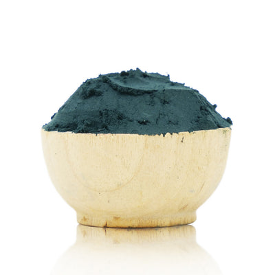 Wooden bowl filled with green powder on a white background