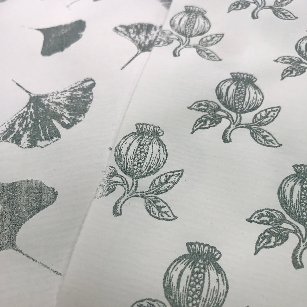 Close-up of fabric with black floral and leaf patterns on a white background