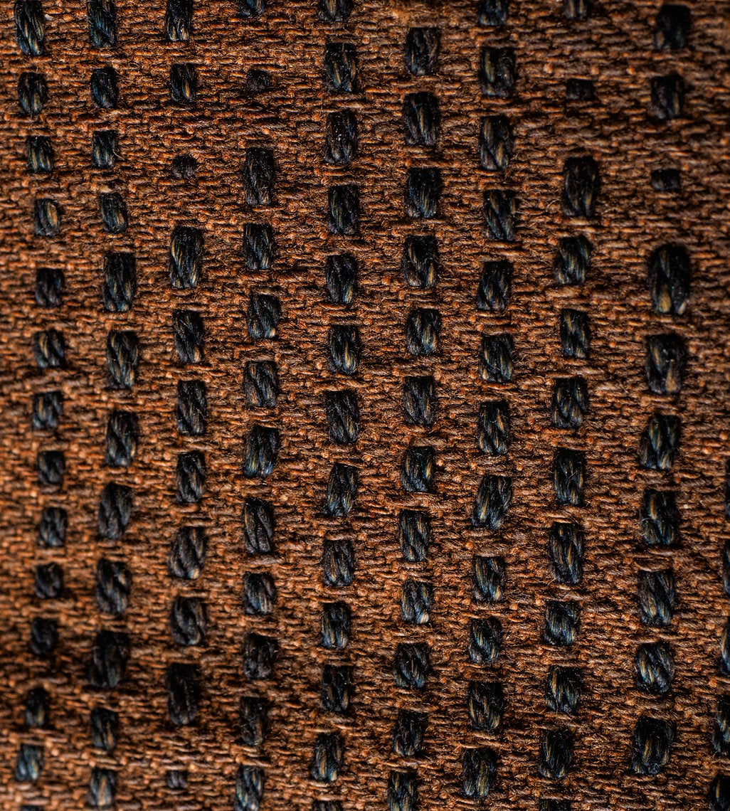 Close-up of a brown textured fabric with a pattern dyed Kakishibu - unripe persimmon tannin extract - Diospyros kaki