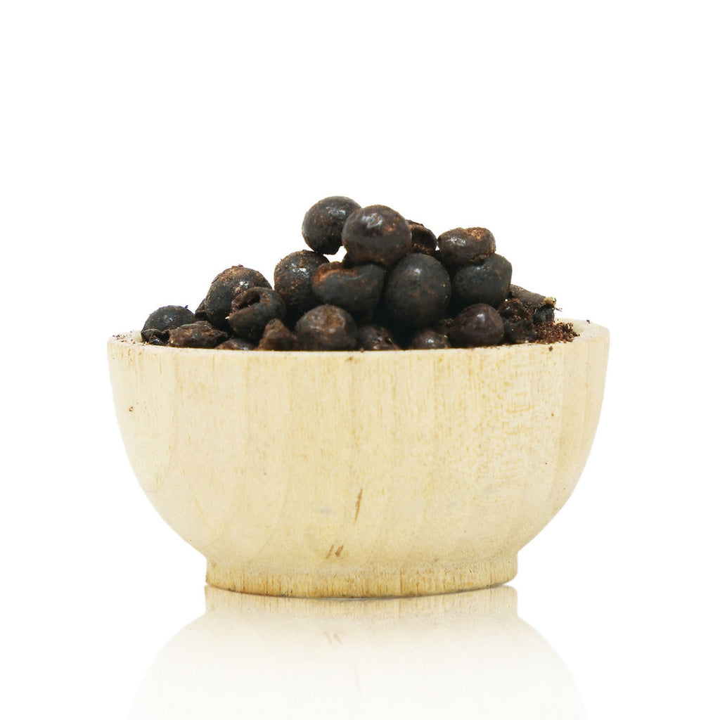 Wooden bowl filled with dark berries on a white background