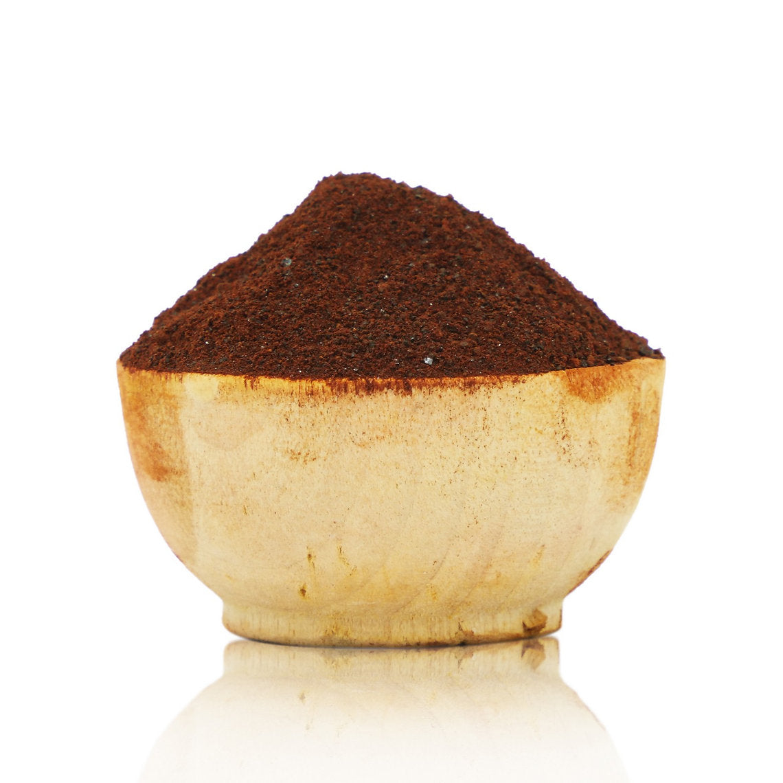 Wooden bowl filled with dark brown powder on a white background