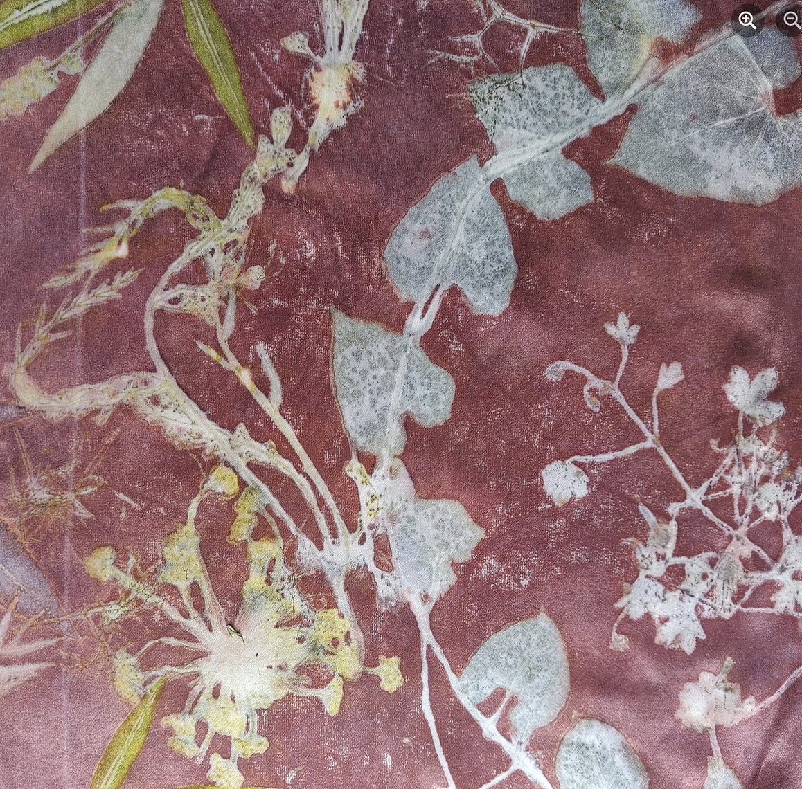Floral pattern with green and white leaves on a textured red-brown background