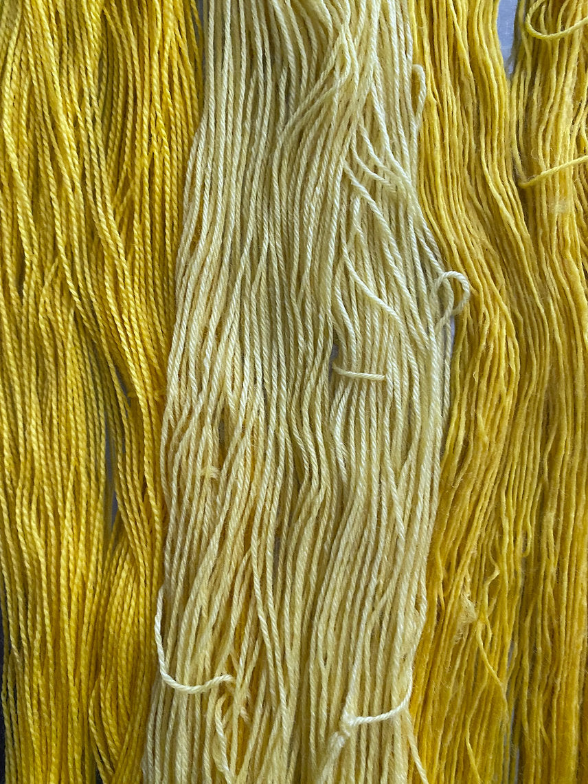 Close-up of yellow and beige yarn strands.