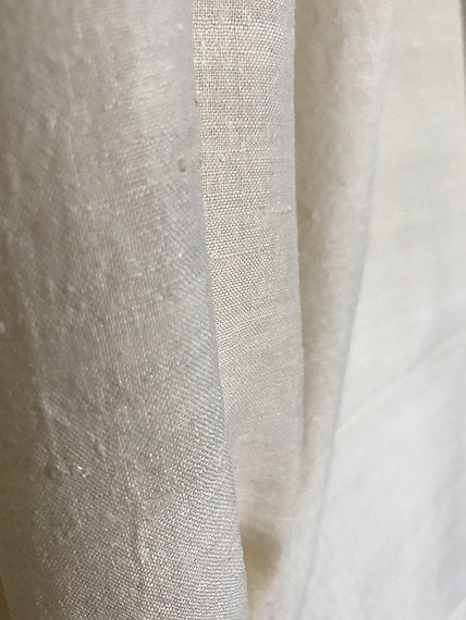 Close-up of a textured white fabric with a subtle pattern.