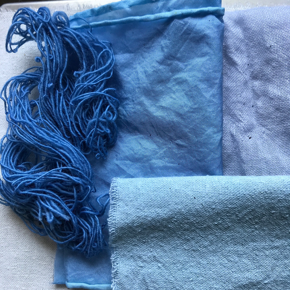 Blue yarn and fabric on a textured surface