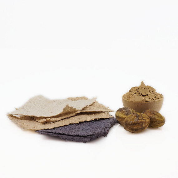 Nuts and a container of brown paste on a white background fabrics samples