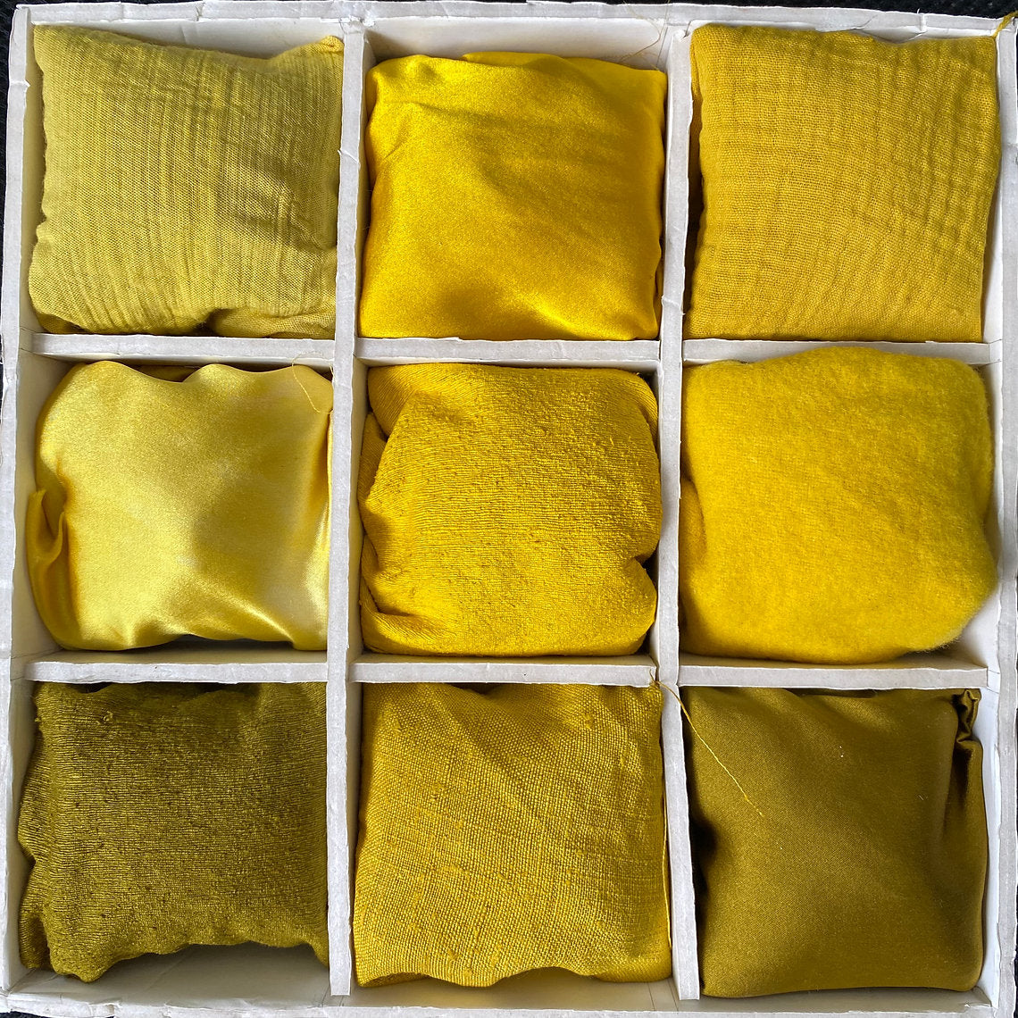 Grid of yellow fabric squares in a box